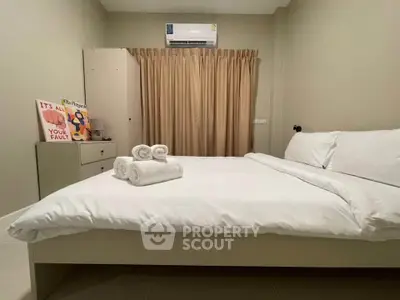 Cozy bedroom with air conditioning and neatly arranged bed linens.