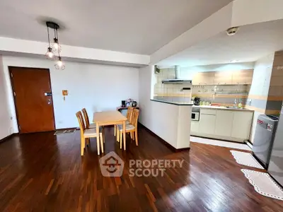 Spacious open-plan living and dining area with modern kitchen and wooden flooring.