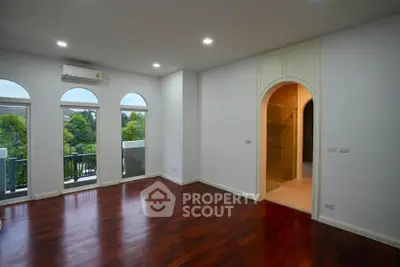 Spacious living room with hardwood floors and balcony access in modern home