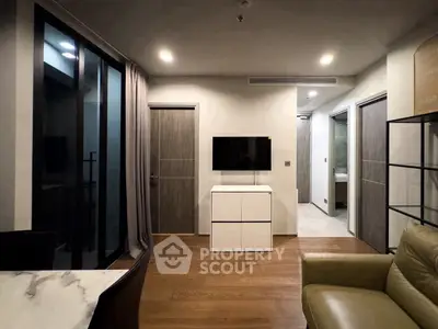 Modern living room with sleek design, featuring a wall-mounted TV, stylish furniture, and elegant lighting.