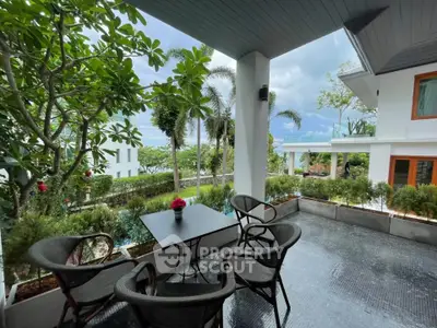 Charming outdoor patio with lush greenery and ocean view, perfect for relaxation and entertaining.
