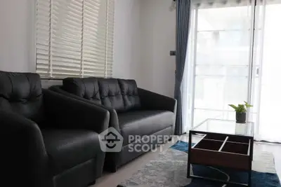 Modern living room with stylish black sofas and large window