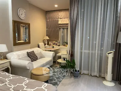 Elegant living room with cozy seating and large window drapes, perfect for relaxation.