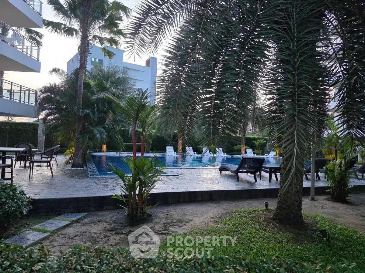 Luxurious poolside oasis with lush greenery and modern seating area.