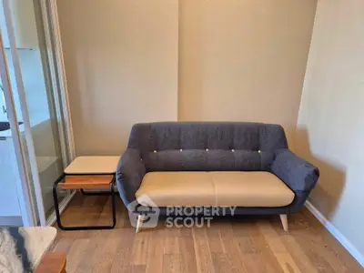 Stylish modern living room with a cozy gray sofa and wooden side table on elegant hardwood flooring.
