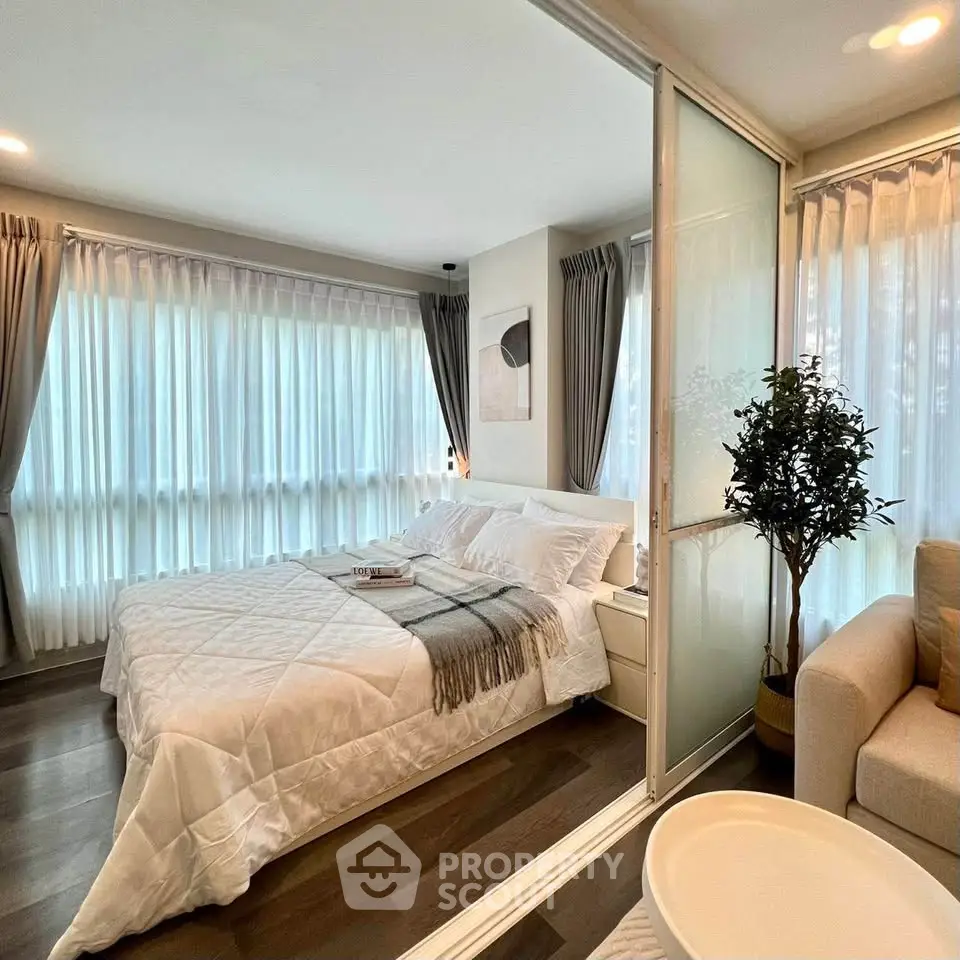 Spacious bedroom with elegant decor and large windows offering natural light.