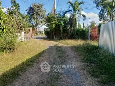 Charming rural driveway leading to a lush garden entrance, perfect for serene living.