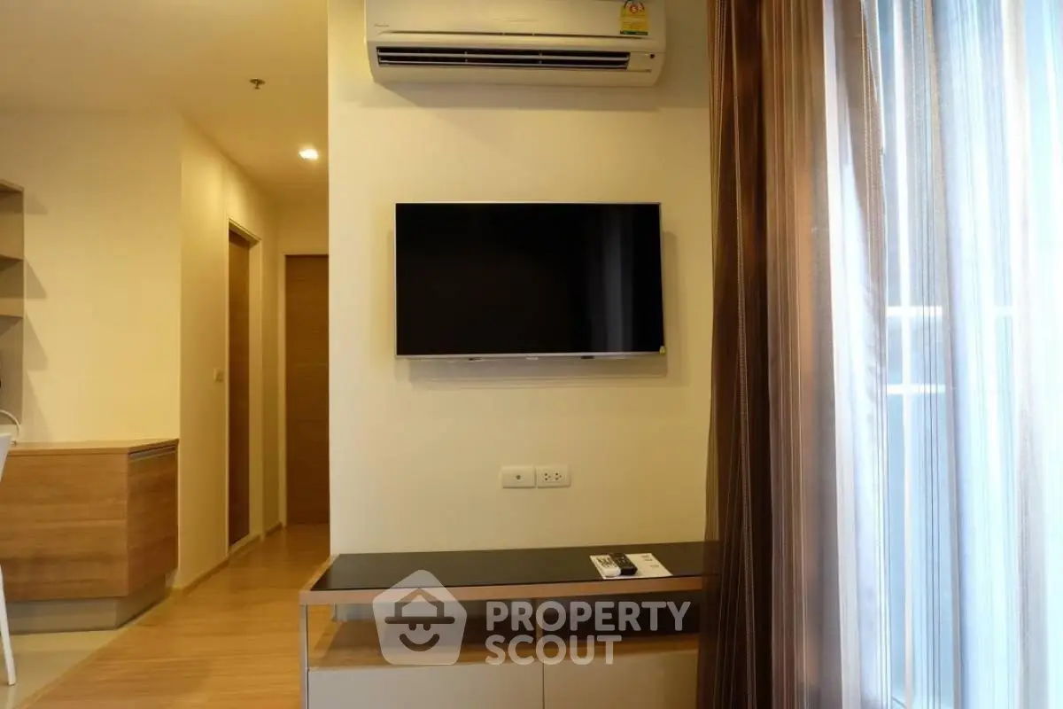 Modern living room with wall-mounted TV and air conditioning in a stylish apartment.