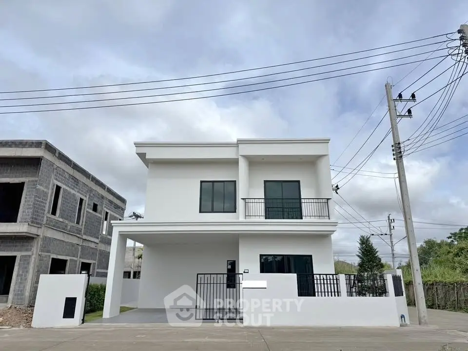 Modern two-story white house with balcony and gated driveway