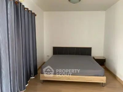 Spacious bedroom with modern bed and elegant curtains in a minimalist design.