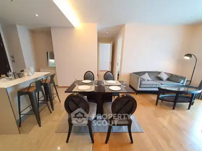 Modern open-plan living and dining area with stylish furniture and wooden flooring.