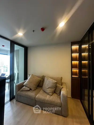 Cozy living room with modern sofa and glass cabinet, perfect for relaxation and style.