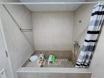 Spacious bathroom with tiled walls and shower area