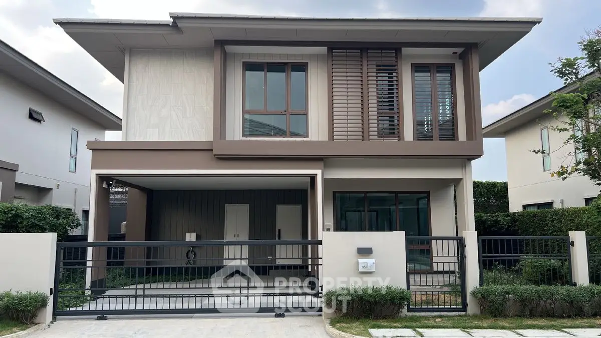 Modern two-story house with sleek design and spacious driveway in a serene neighborhood.