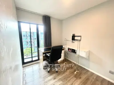 Modern study room with sleek desk and chair, large window offering city view, perfect for productivity.