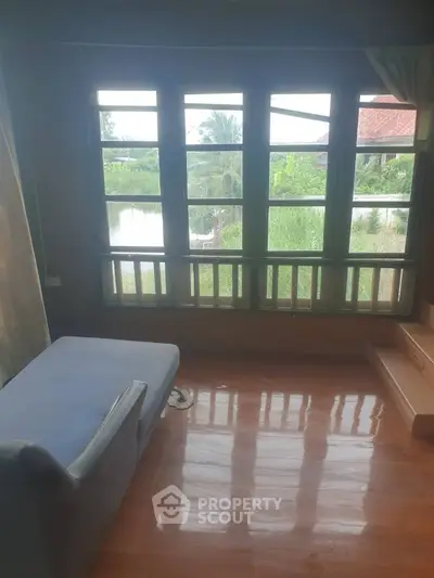 Charming room with large windows offering serene river views and natural light, perfect for relaxation.