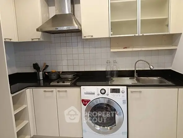 Modern kitchen with sleek cabinetry and built-in washing machine