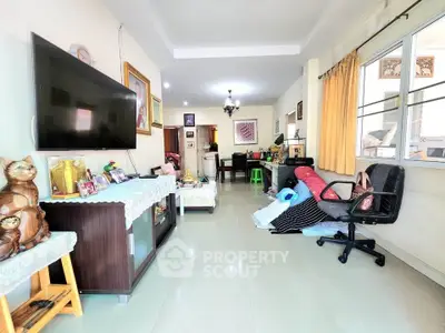 Spacious living room with modern decor and large TV, perfect for family gatherings.