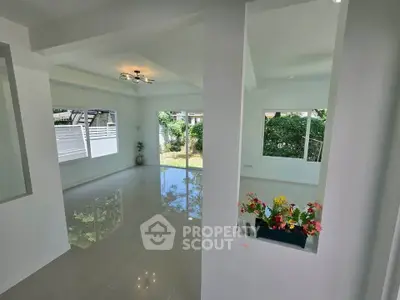 Spacious modern living room with large windows and glossy tiled floors
