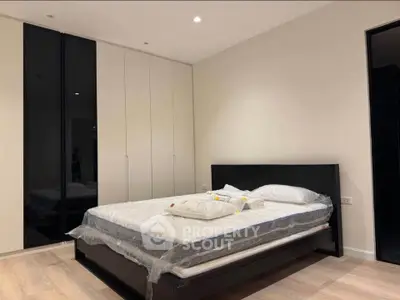 Modern bedroom with sleek design and ample storage in a contemporary apartment.