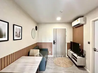 Modern living room with stylish decor and air conditioning, featuring a cozy sofa and wall-mounted TV.