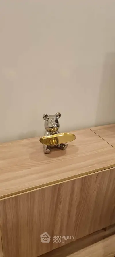 Modern interior with stylish wooden cabinet and decorative bear sculpture.