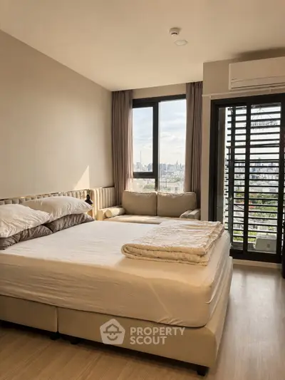 Modern bedroom with city view, featuring a cozy bed and stylish decor in a high-rise apartment.
