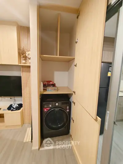 Modern laundry area with built-in wooden cabinetry and washing machine