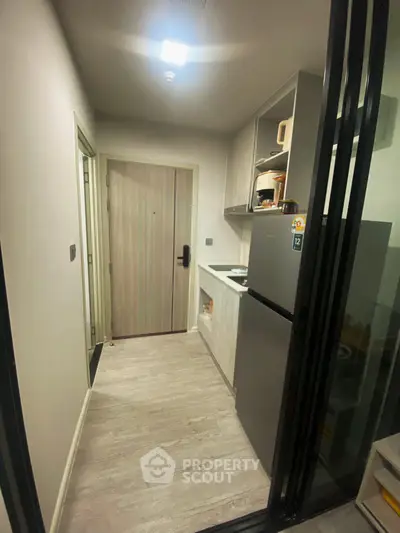 Modern compact kitchen with sleek appliances and stylish cabinetry in a cozy apartment.