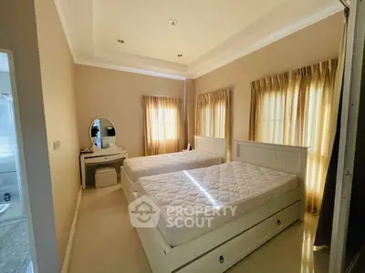Cozy bedroom with twin beds and natural light, perfect for relaxation.