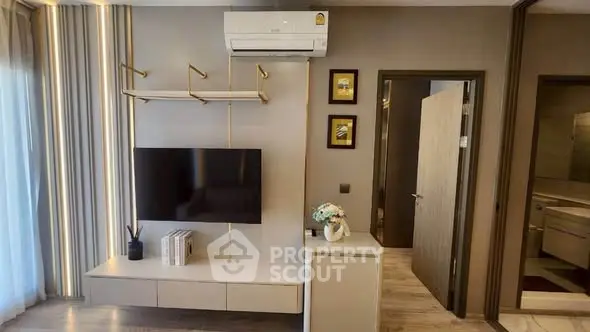 Modern living room with wall-mounted TV and air conditioning in stylish apartment.