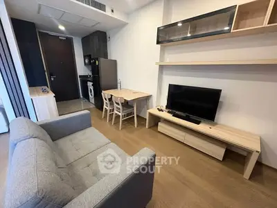 Modern living room with cozy sofa, TV, and dining area in stylish apartment.
