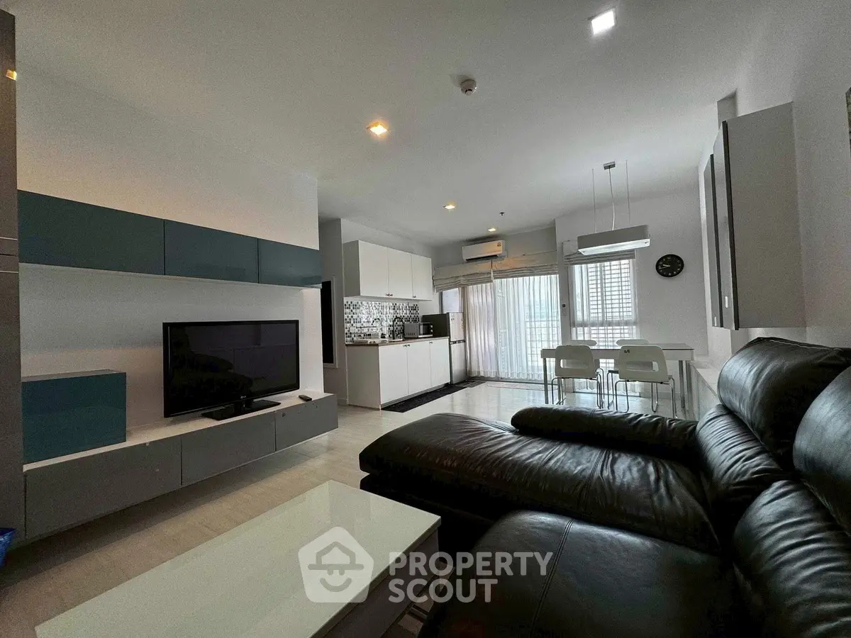 Modern living room with sleek furniture and open kitchen layout, perfect for contemporary living.