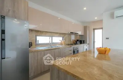 Modern kitchen with marble countertops and sleek appliances in a stylish open layout.