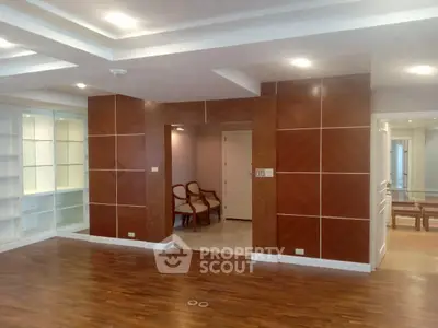 Spacious modern living room with wooden flooring and elegant wall paneling