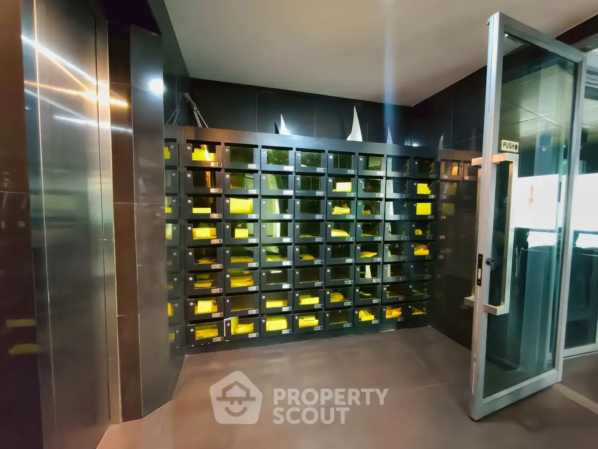 Modern building entrance with sleek mailboxes and glass door, showcasing contemporary design and functionality.