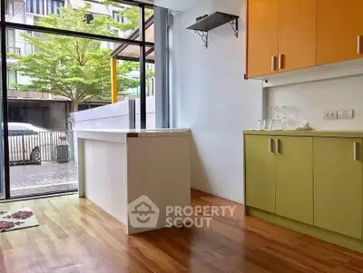 Bright kitchen with colorful cabinets and large window view
