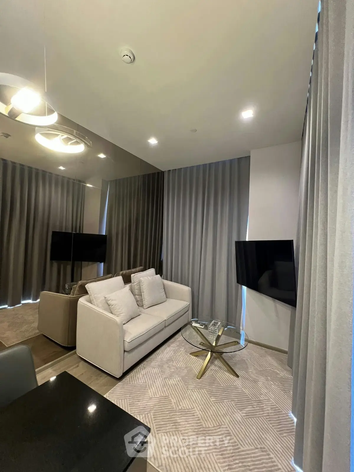 Modern living room with elegant decor, featuring a cozy sofa, stylish coffee table, and ambient lighting.