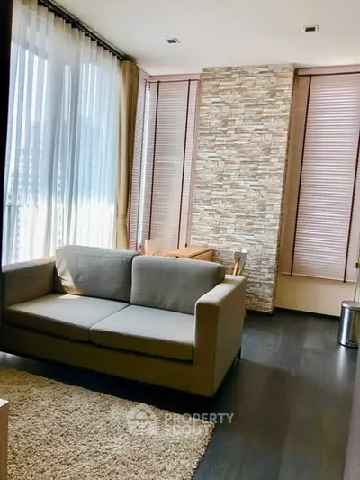 Modern living room with large windows and stylish stone accent wall
