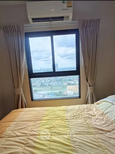 Cozy bedroom with stunning city view from large window, perfect for relaxation.