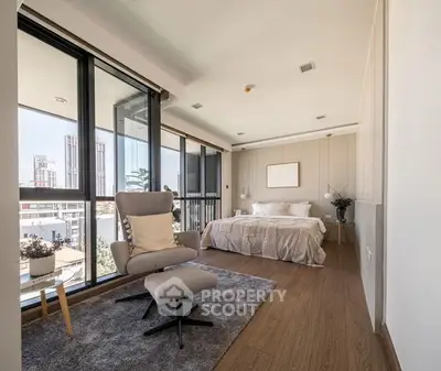 Spacious bedroom with large windows offering ample natural light, modern furnishings, and direct balcony access, perfect for urban living.