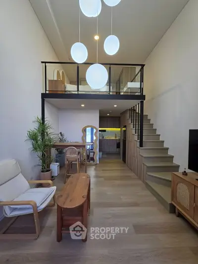 Modern loft apartment with stylish mezzanine and open kitchen layout, featuring elegant wooden furniture and bright lighting.