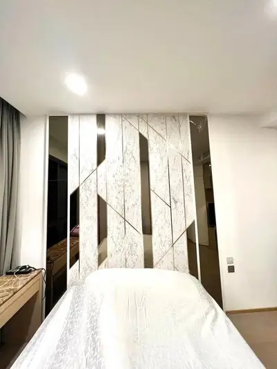 Modern bedroom with stylish marble accent wall and elegant decor