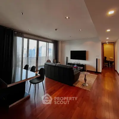 Spacious modern living room with hardwood floors and city view balcony.