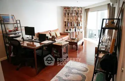 Spacious living room with modern decor and ample natural light, featuring a cozy seating area and stylish shelving.