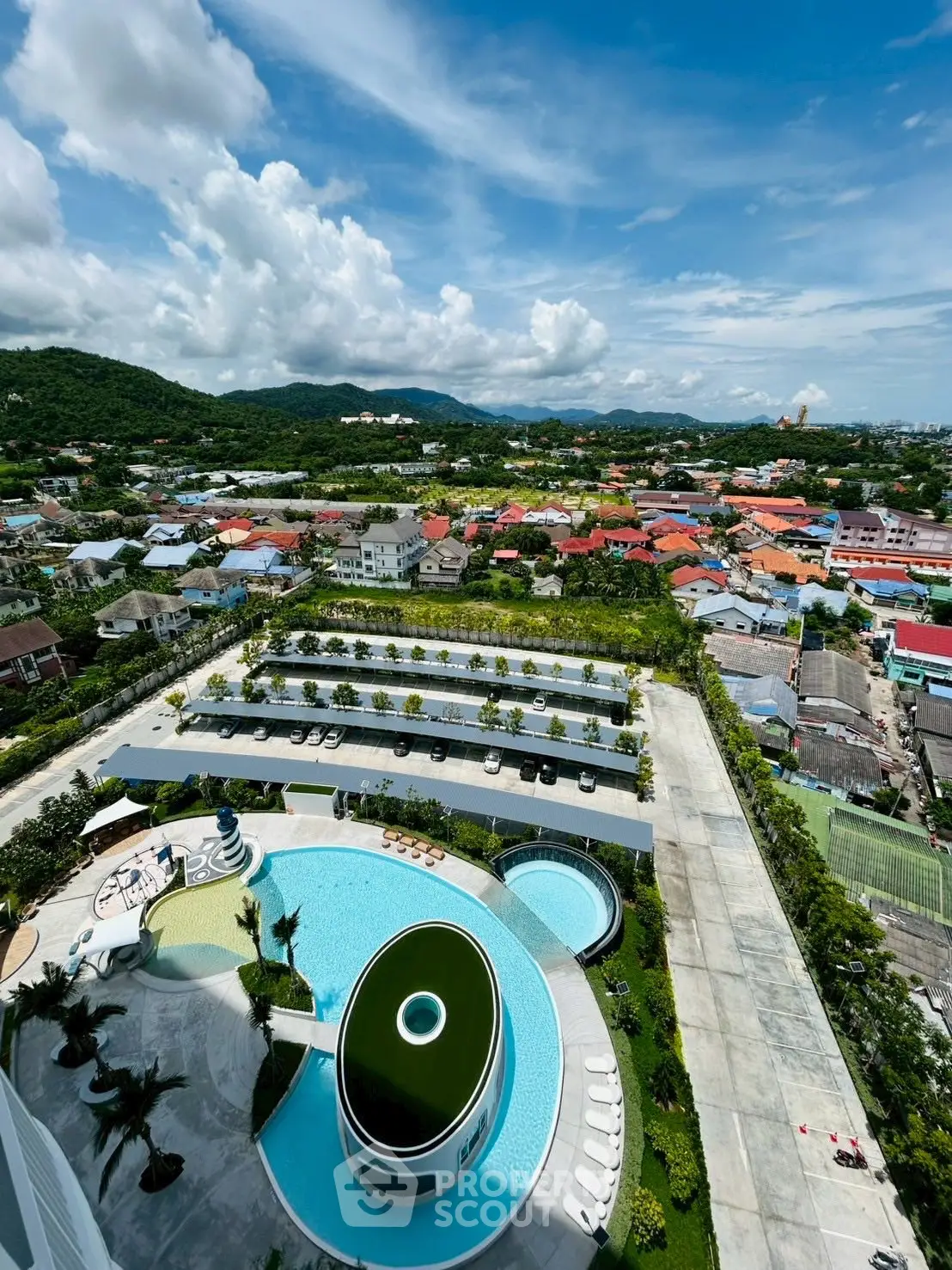 Stunning aerial view of luxury apartment complex with pool and lush surroundings.