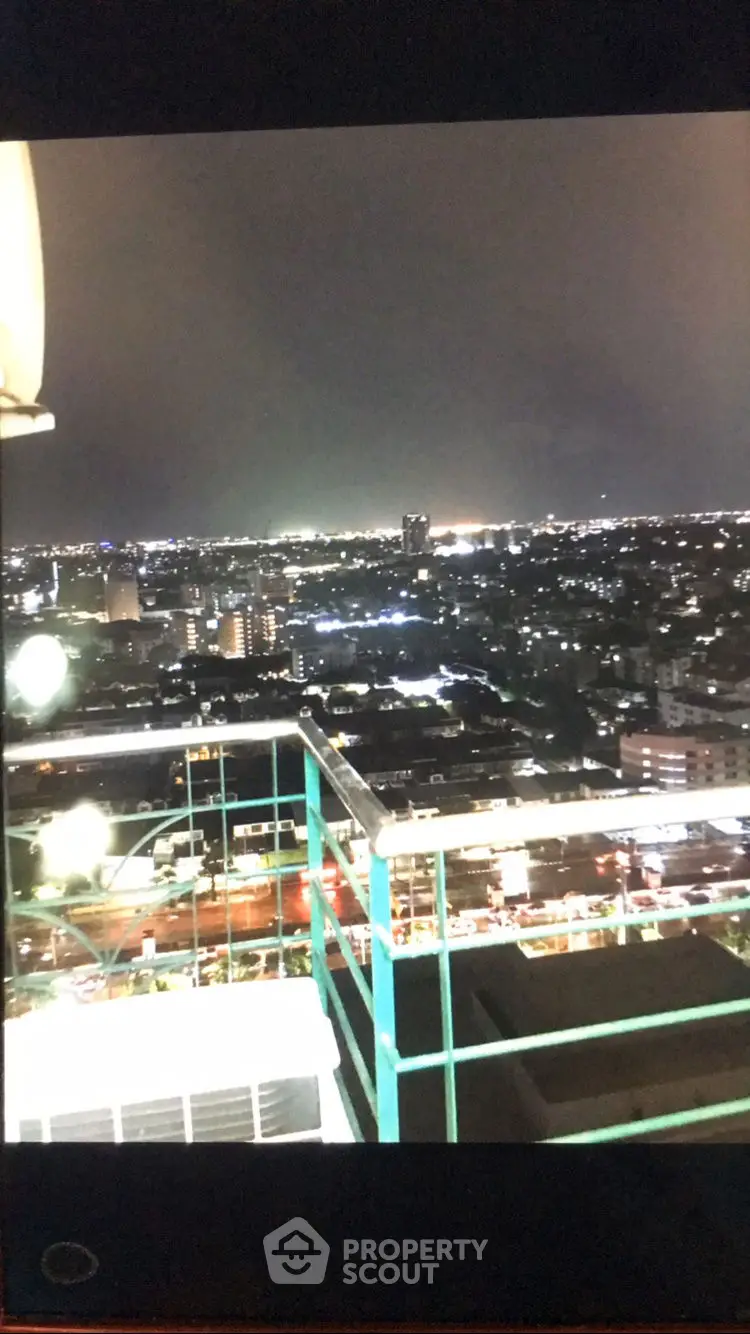 Stunning cityscape night view from high-rise balcony, showcasing vibrant urban lights.