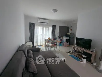 Spacious living room with modern furniture and natural light, ideal for family gatherings.