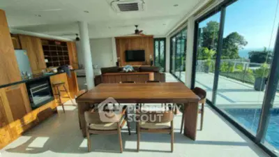 Luxurious open-plan living room with pool view and modern wooden furniture