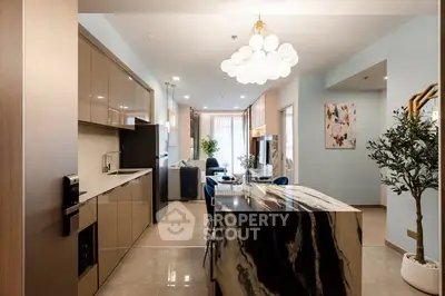 Modern open-layout kitchen and living room with elegant marble island and chic lighting.